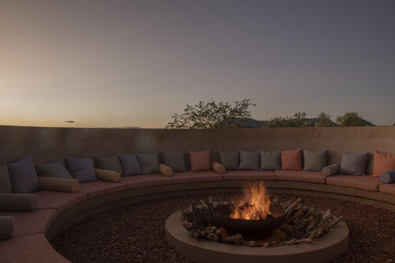 A round boma with cushioned seats and a firepit