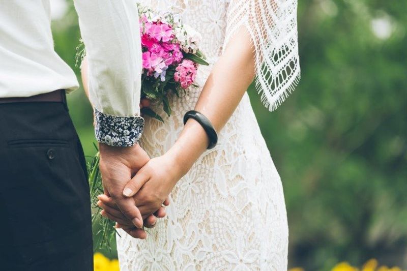 Ein Hochzeitspaar hält Händchen