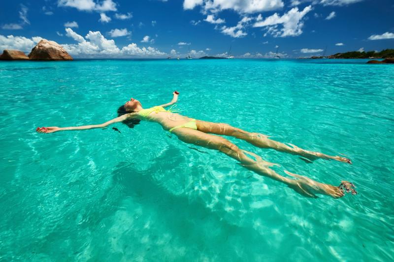 Girl floating in water in the Seychelles