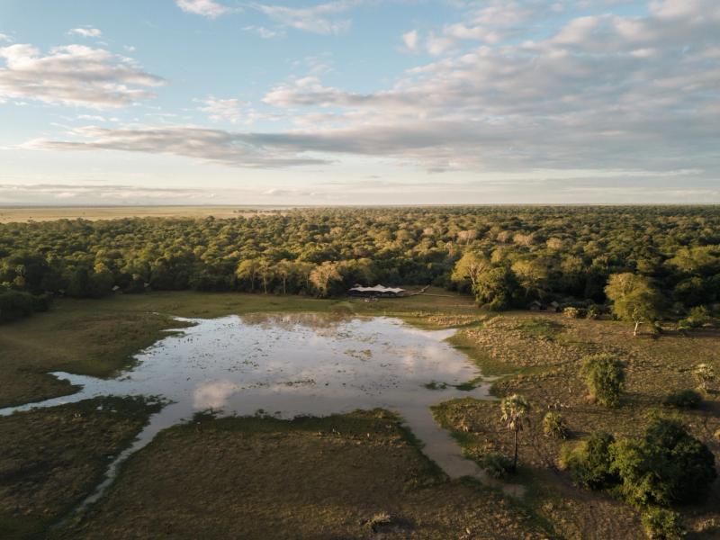 Aerial view of Chicari Camp surrounded by woodland and seasonal wetlands in Mozambique's Gorongosa National Park.