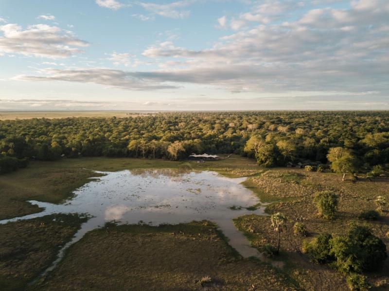 Aerial view of Chicari Camp surrounded by woodland and seasonal wetlands in Mozambique's Gorongosa National Park.