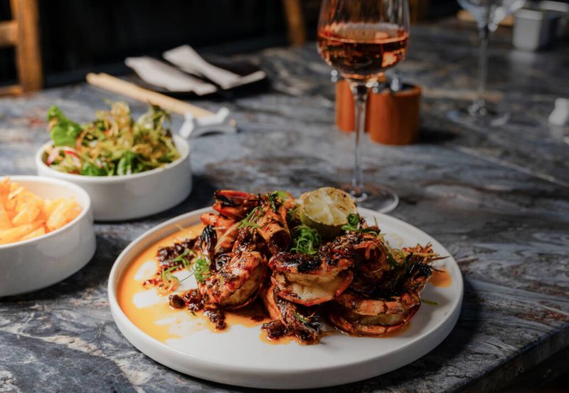 A plate of flame-grilled prawns on a marble counter