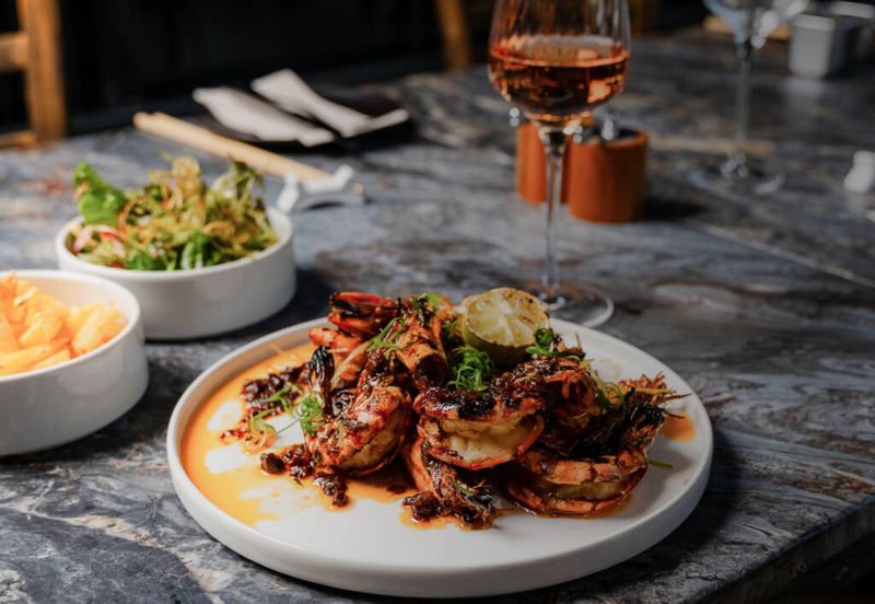 A plate of flame-grilled prawns on a marble counter
