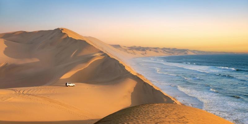 Car near Sandwich Harbour, where the dunes meet the ocean