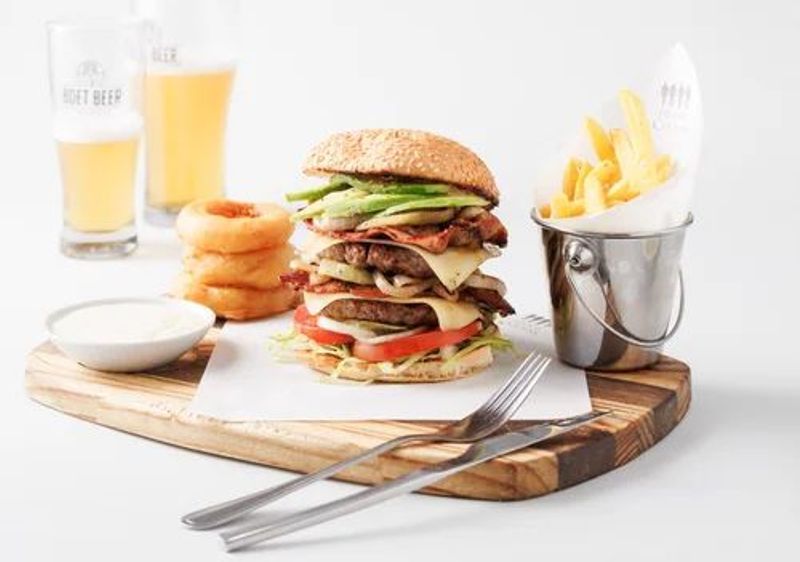 Double stacked burger served with fries, onion rings, dipping sauce and two glasses of beer