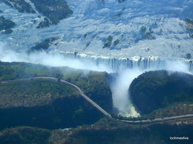 We asked our pilot if he wouldn't mind taking a turn around the falls so we could have another look, an aerial look. Here you can see the Zambezi bridge, on the left is Zimbabwe and on the right, Zambia ... 