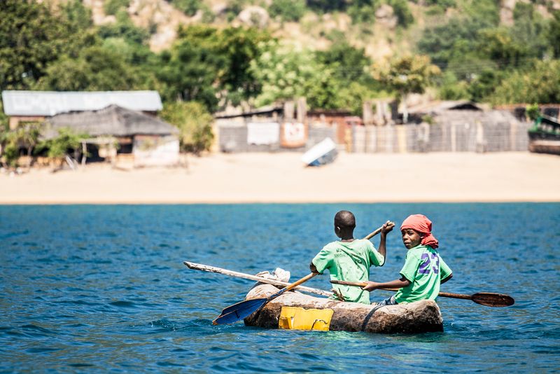 Two boys canoeing on Lake Malawi