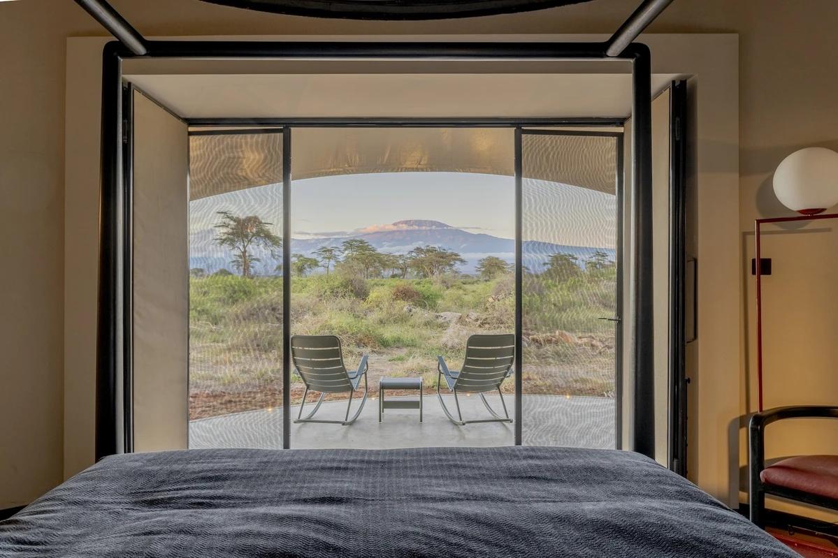 Angama Amboseli guest tent interior, with a comfortable bed and views of the surrounding landscape.