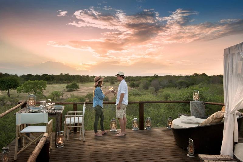 Couple enjoying a sundowner at a treehouse sleep-out in South Africa