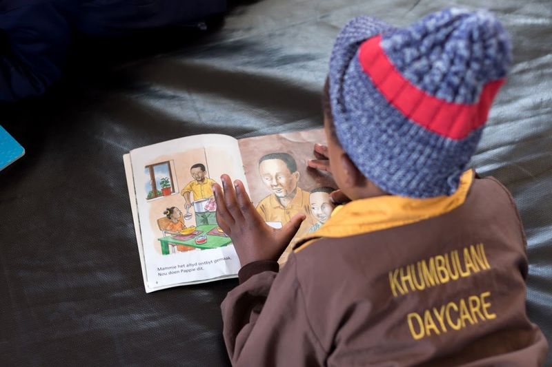 Reading a book in Khumbulani uniform