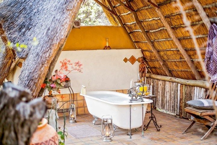 A freestanding bath under a thatched roof