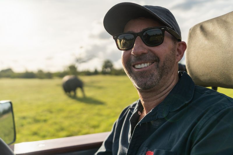 Rhino Africa CEO, David Ryan, photographed sitting in a game drive vehicle with an elephant in the background