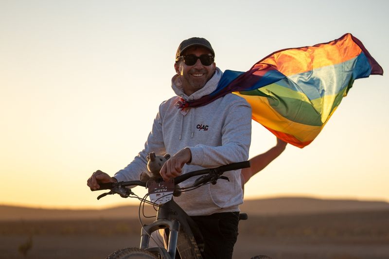 David Ryan wearing a LGBTQ+ flag