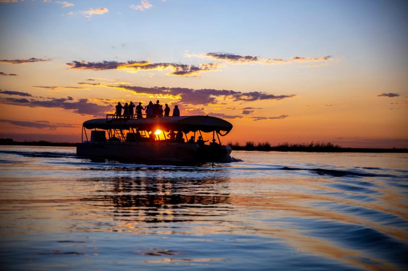 A silhouette of a sunset boat cruise on the chobe river 