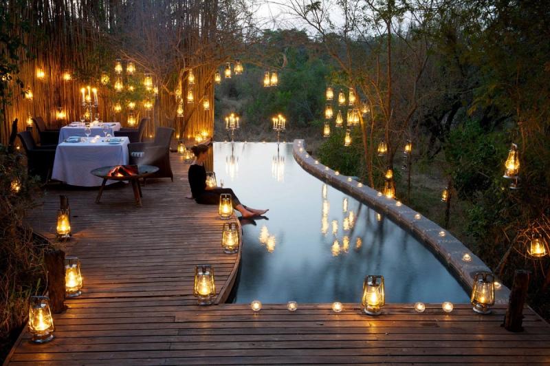 Dîner romantique à la bougie au bord de la piscine en safari à Londolozi, Afrique.
