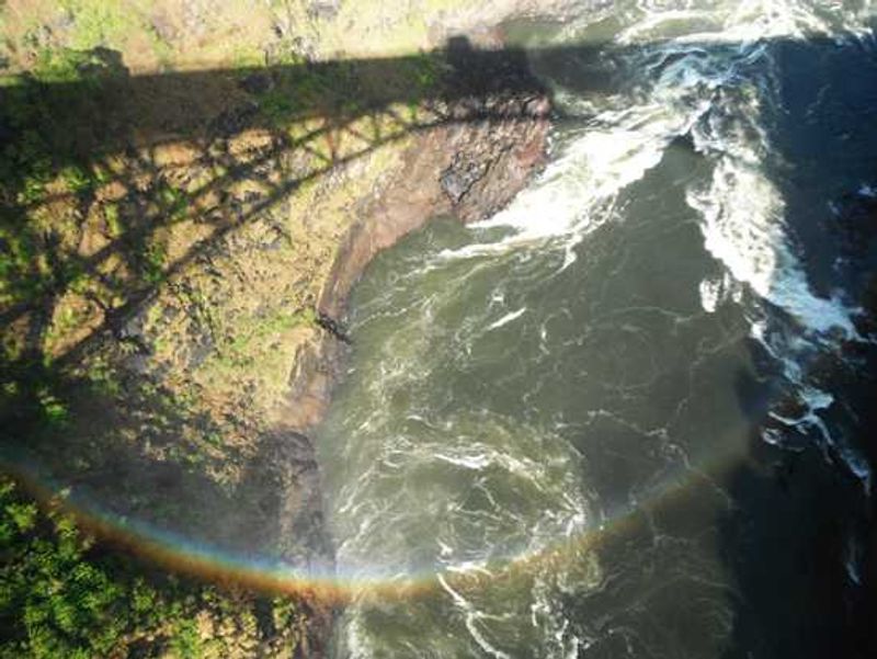 A rainbow shines by the bridge over the Zambezi River on the Zimbabwe side