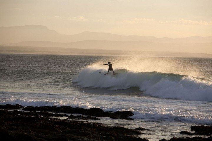 Un surfista en la costa de Jeffrey's Bay, Sudáfrica