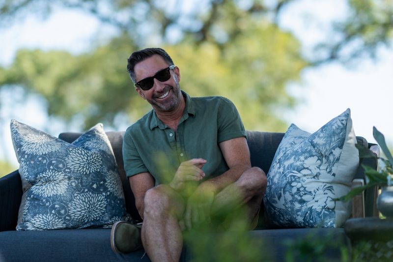 David Ryan sitting on a couch in the middle of the bush