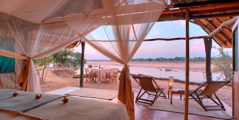 Offenes Zelt mitten in der afrikanischen Wildnis mit Blick aufs Wasser