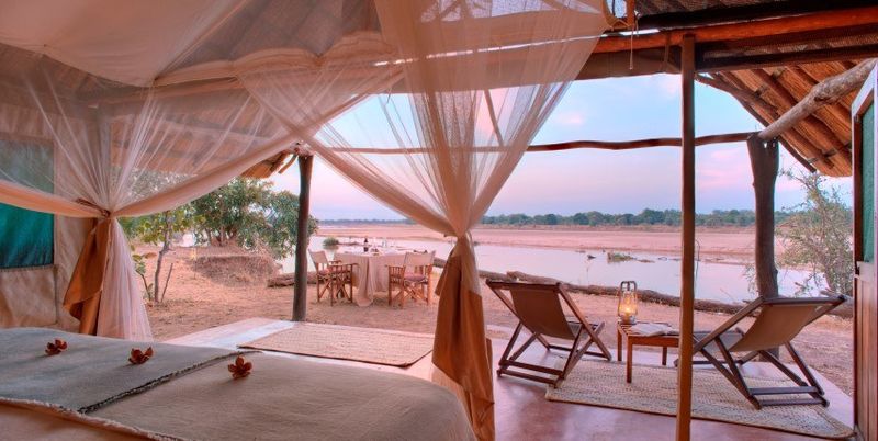 Offenes Zelt mitten in der afrikanischen Wildnis mit Blick aufs Wasser