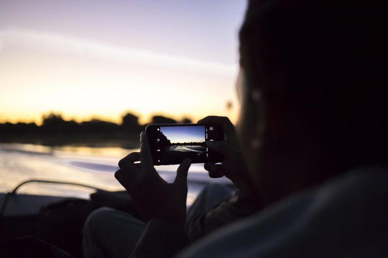 Rhino Africa travel expert on a sunset river cruise on the Okavango Delta