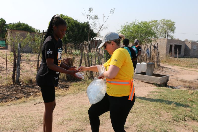 Volunteer giving a runner some water