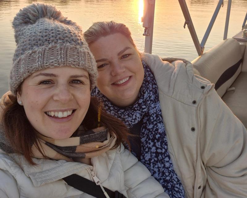 Our travel experts Ali and Kristy wearing warm jackets on an early morning river cruise