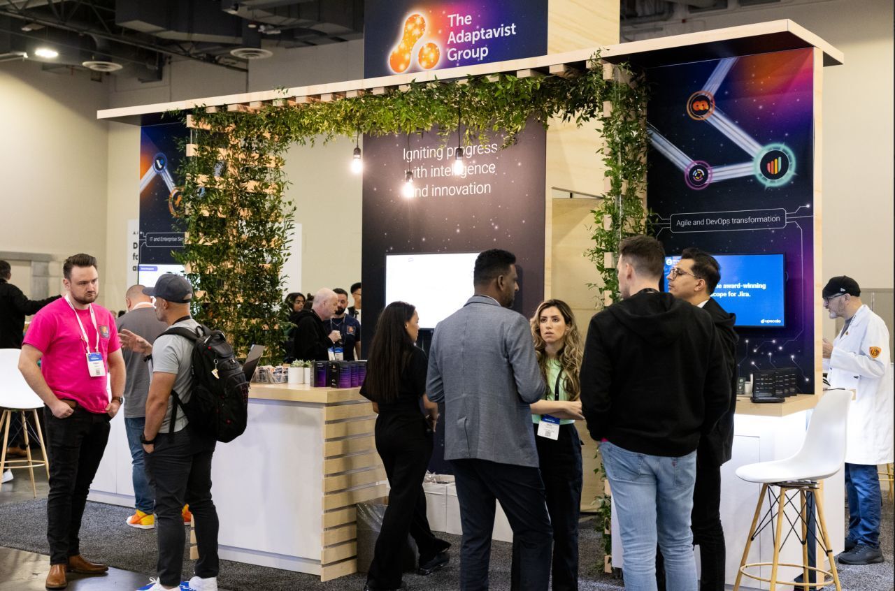 People standing around The Adaptavist Group booth at Team 24