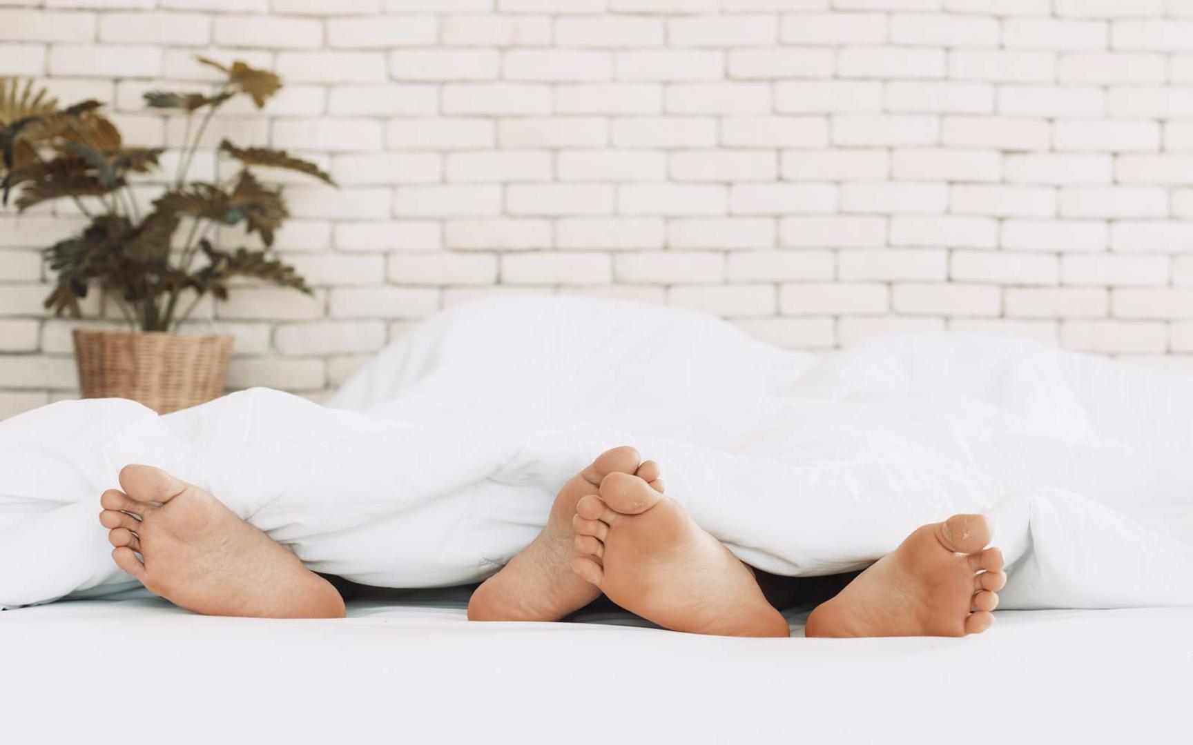 Føttene på et par under dynen