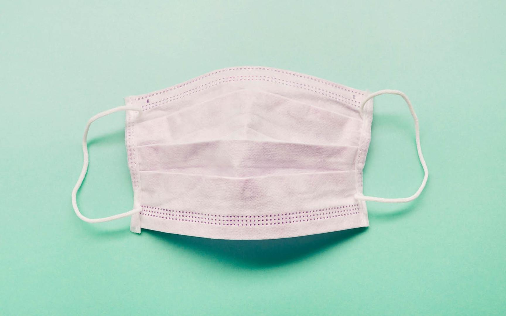 Bilde av et munnbind liggende på en grønn flate.