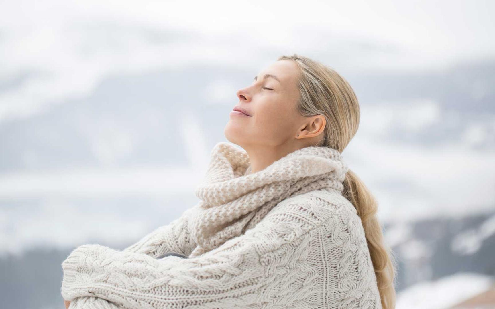 Kvinne sitter i vintersol