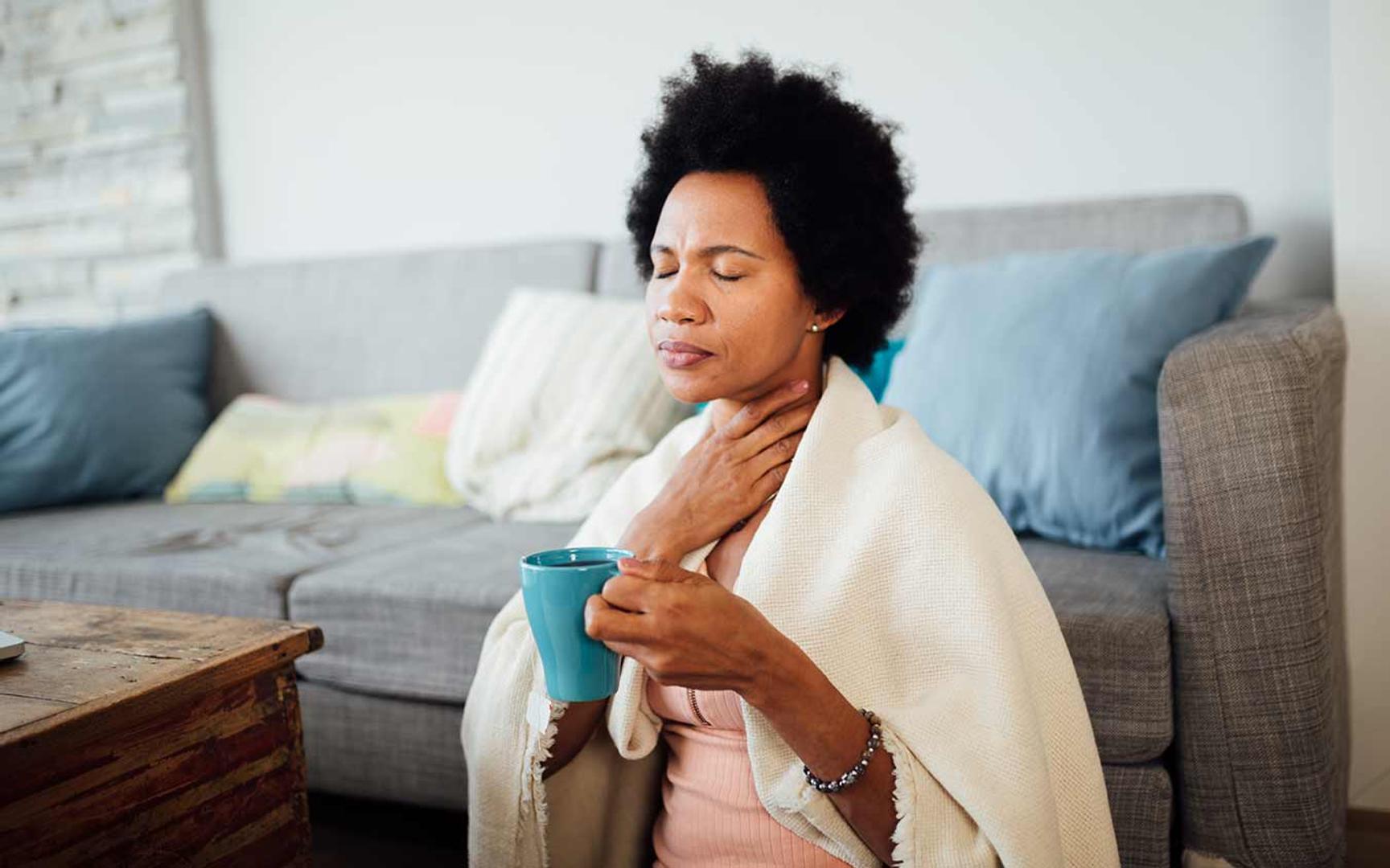 Kvinne som tar seg til halsen