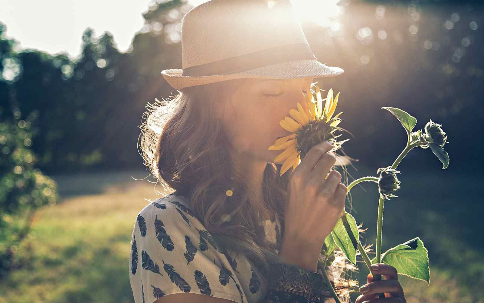 Kvinne som lukter på blomst