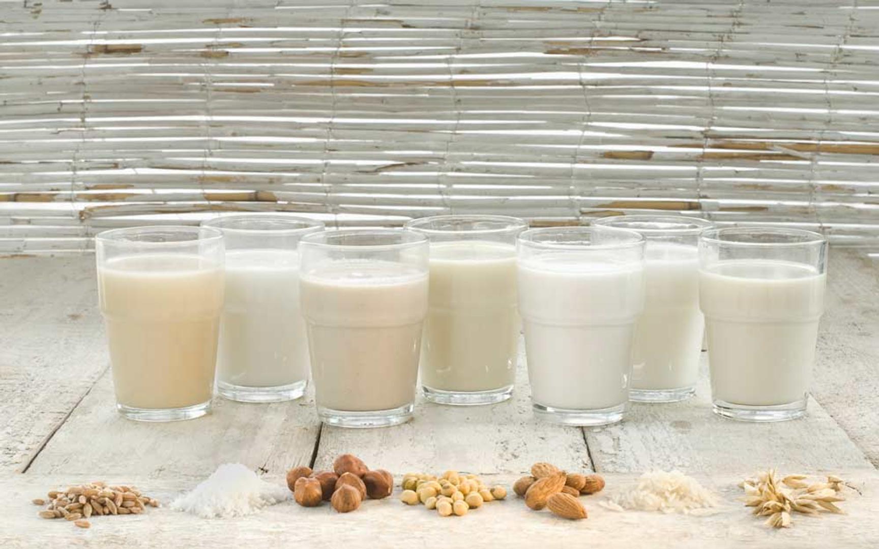 Flere glass med ulike plantebaserte melkealternativer laget av nøtter, korn og belgfrukter.