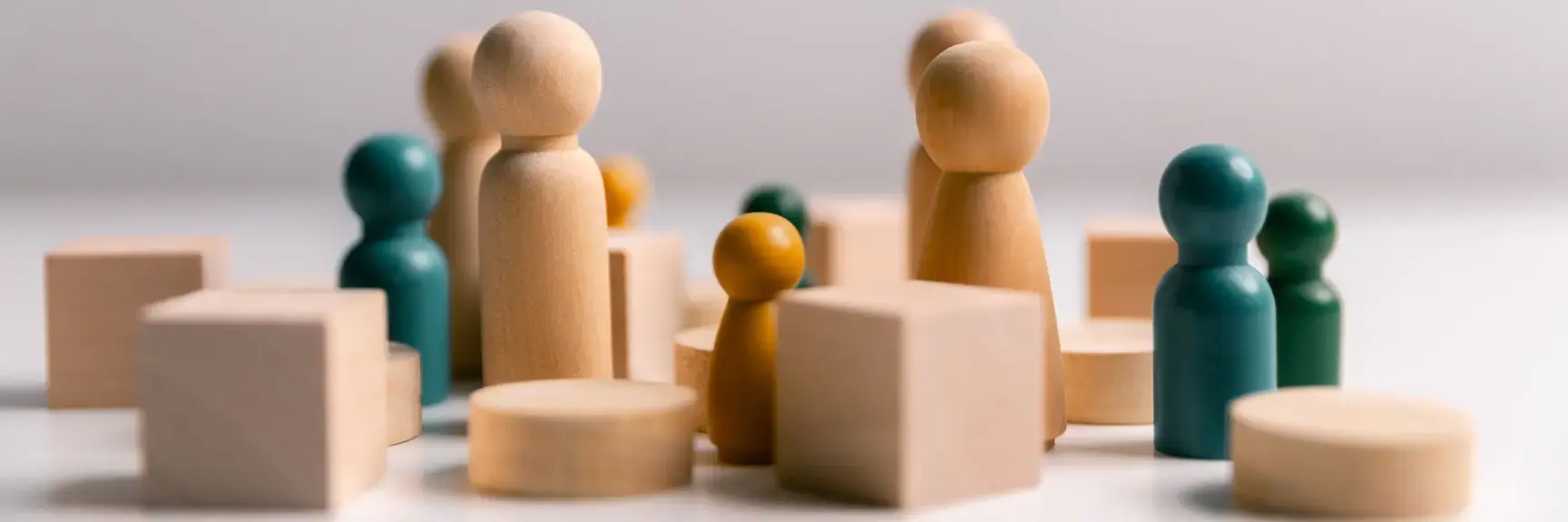 Nærbilde av mange ulike treklosser i ulike former og farger satt sammen i en rotete oppstilling på et bord