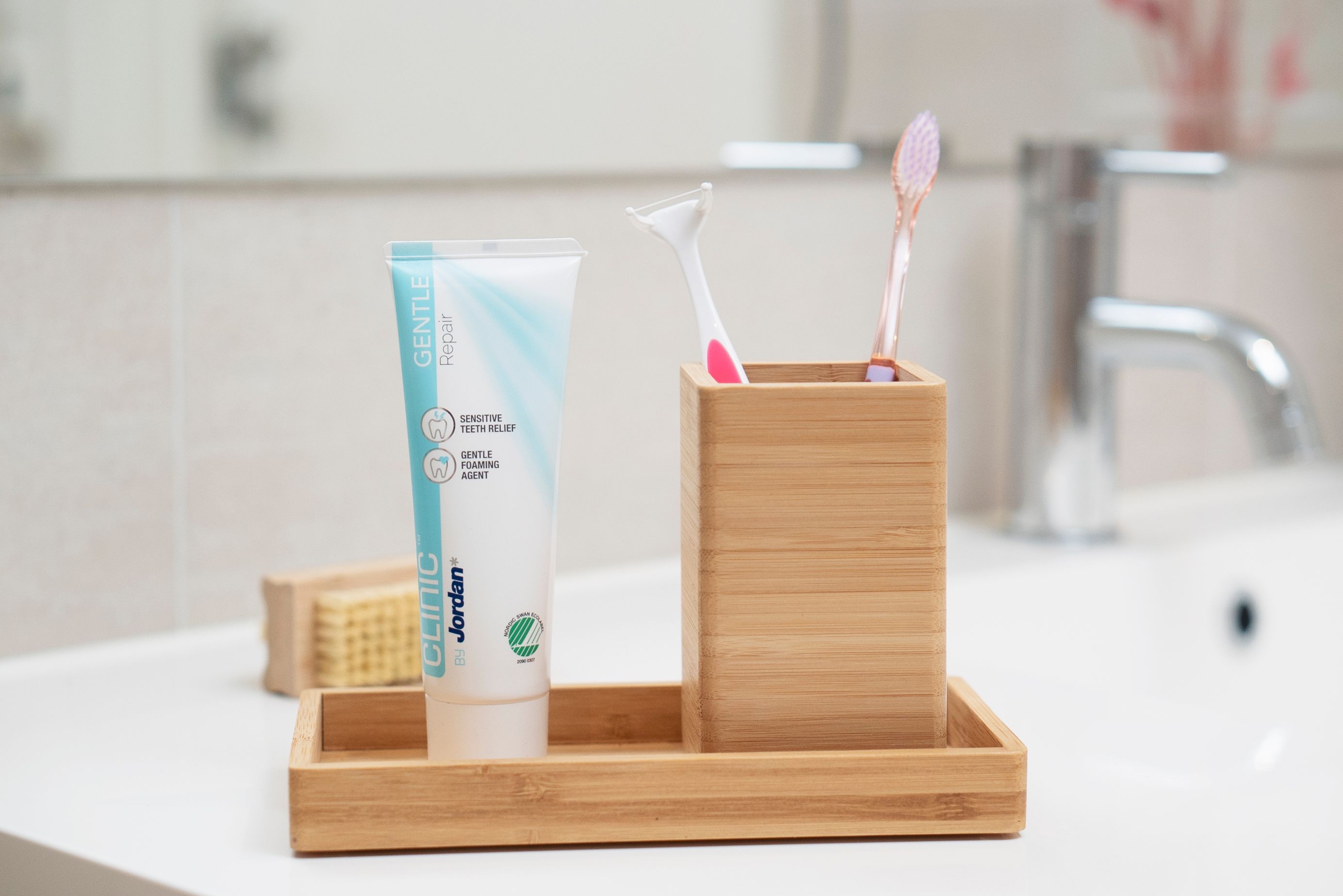 Bilde av tannglass med to tannbørster og en tannkrem