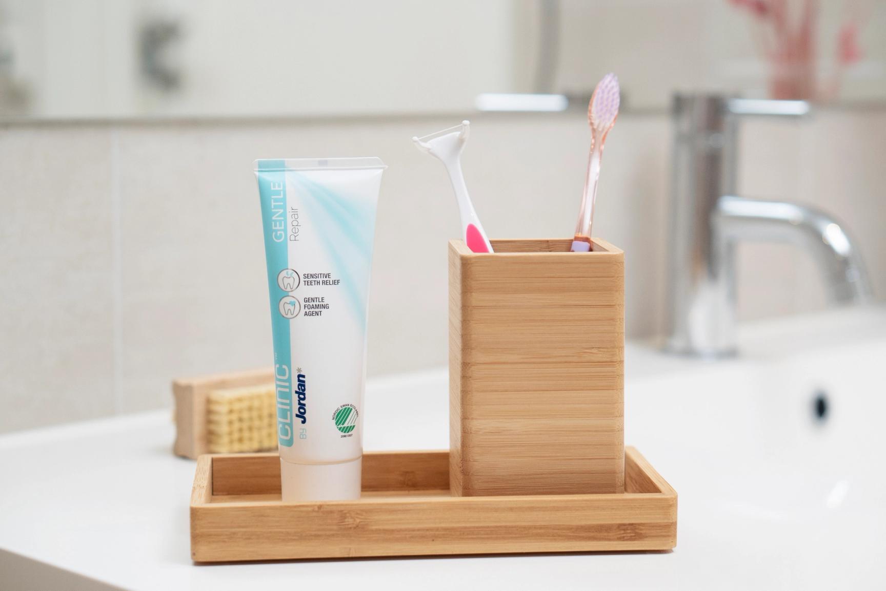 Bilde av tannglass med to tannbørster og en tannkrem