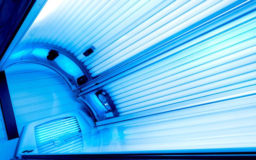 Bildet viser innsiden av et solarium med blått lys fra lysrørene.