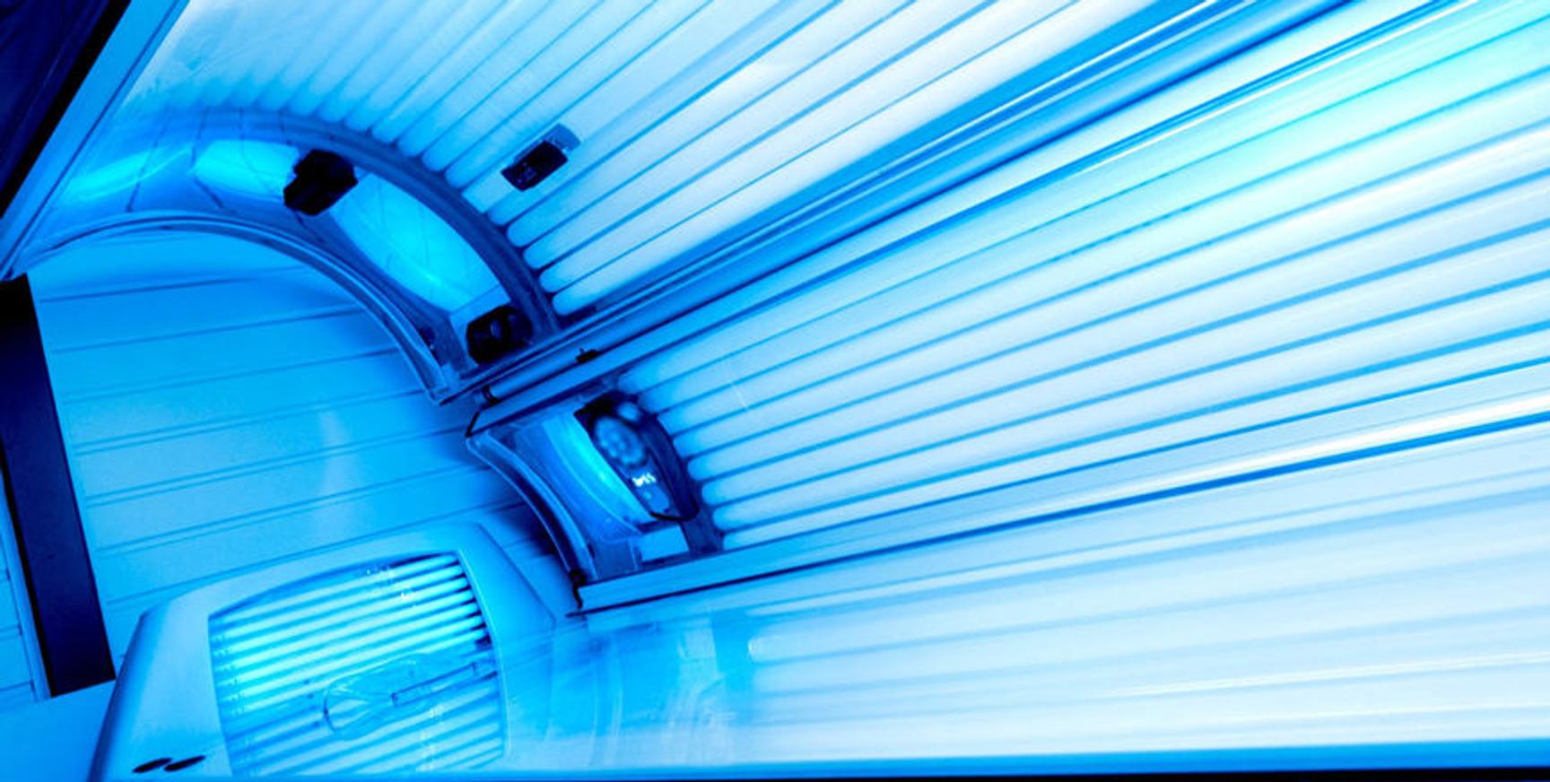 Bildet viser innsiden av et solarium med blått lys fra lysrørene.