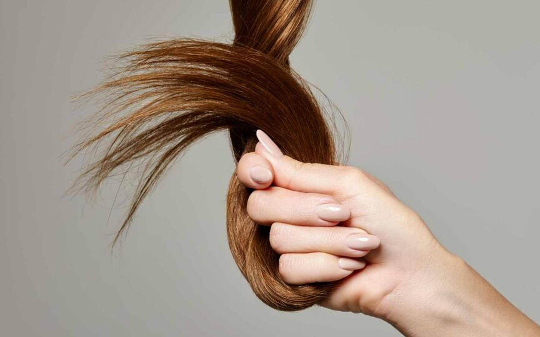 En hånd som holder sundt og vakkert hår