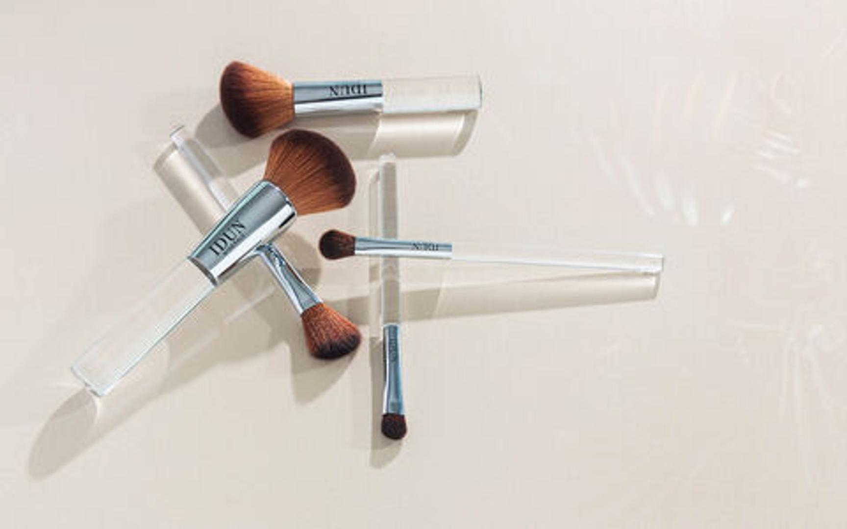 Flere sminkekoster ligger på et bord