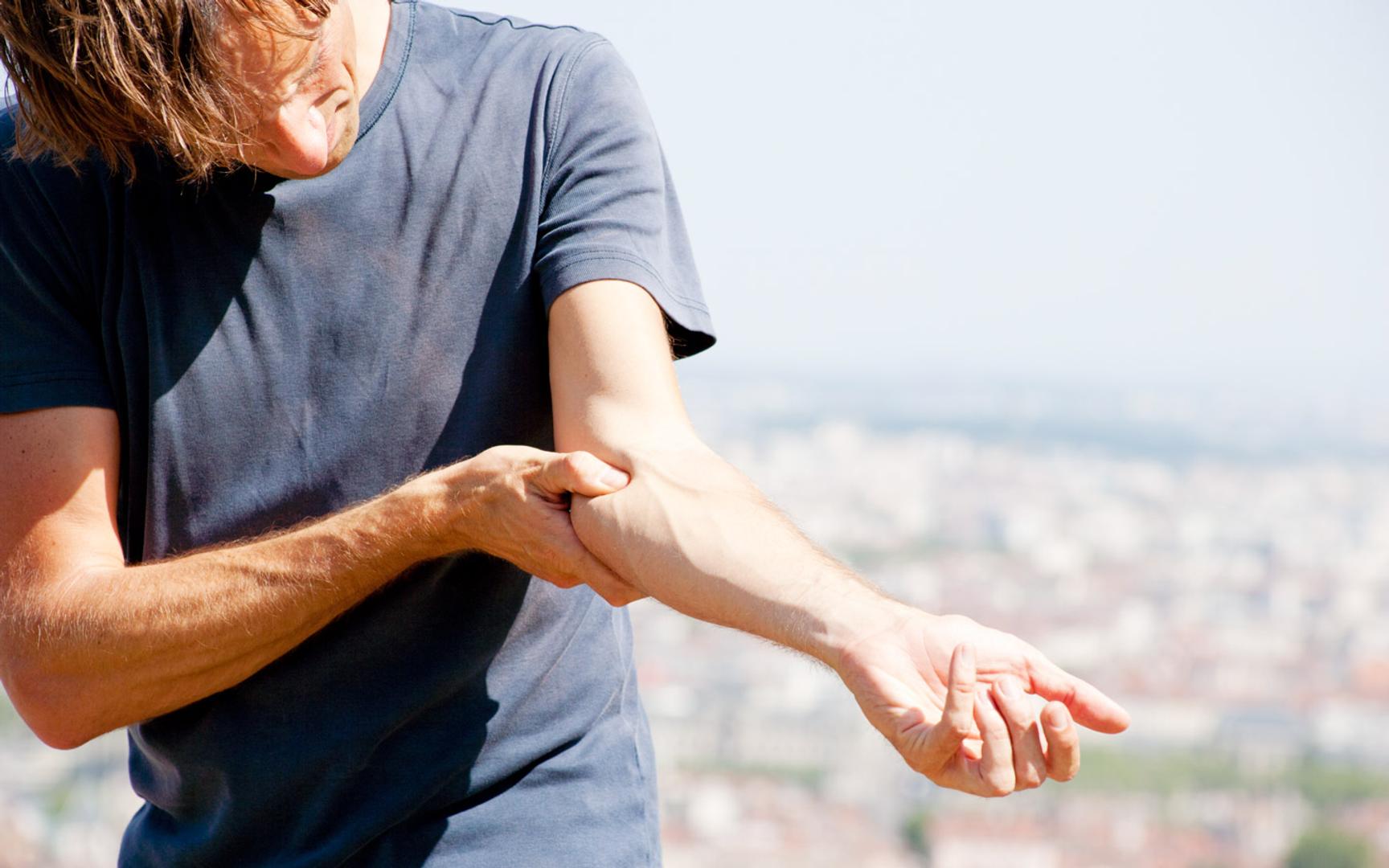 En mann som presser tommelen på underarmen