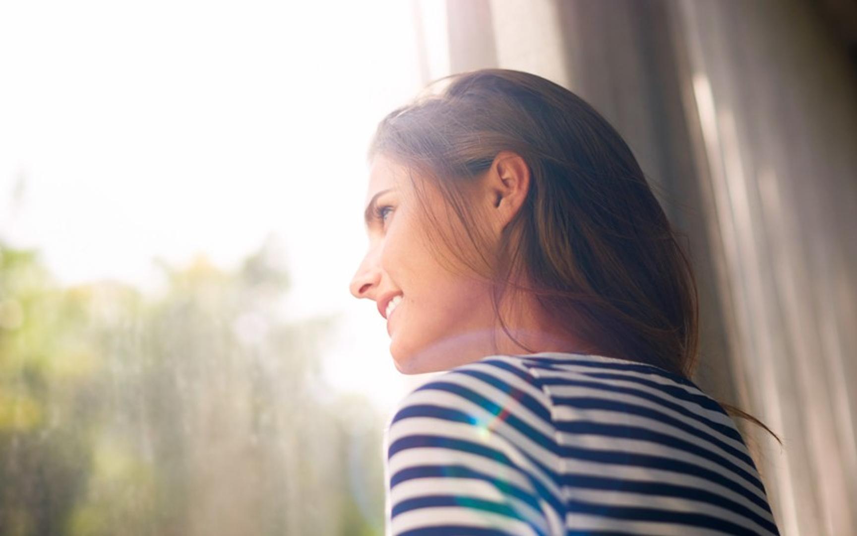 En kvinne ser ut av et vindu