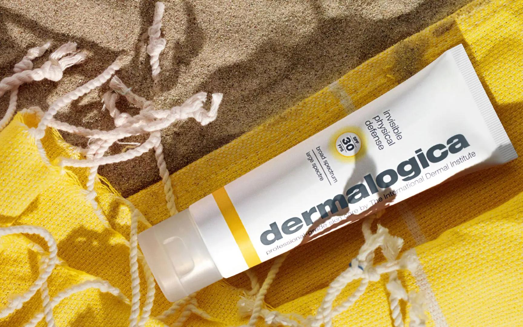 Bilde av solkrem dermalogica som ligger på et gult pledd i solen