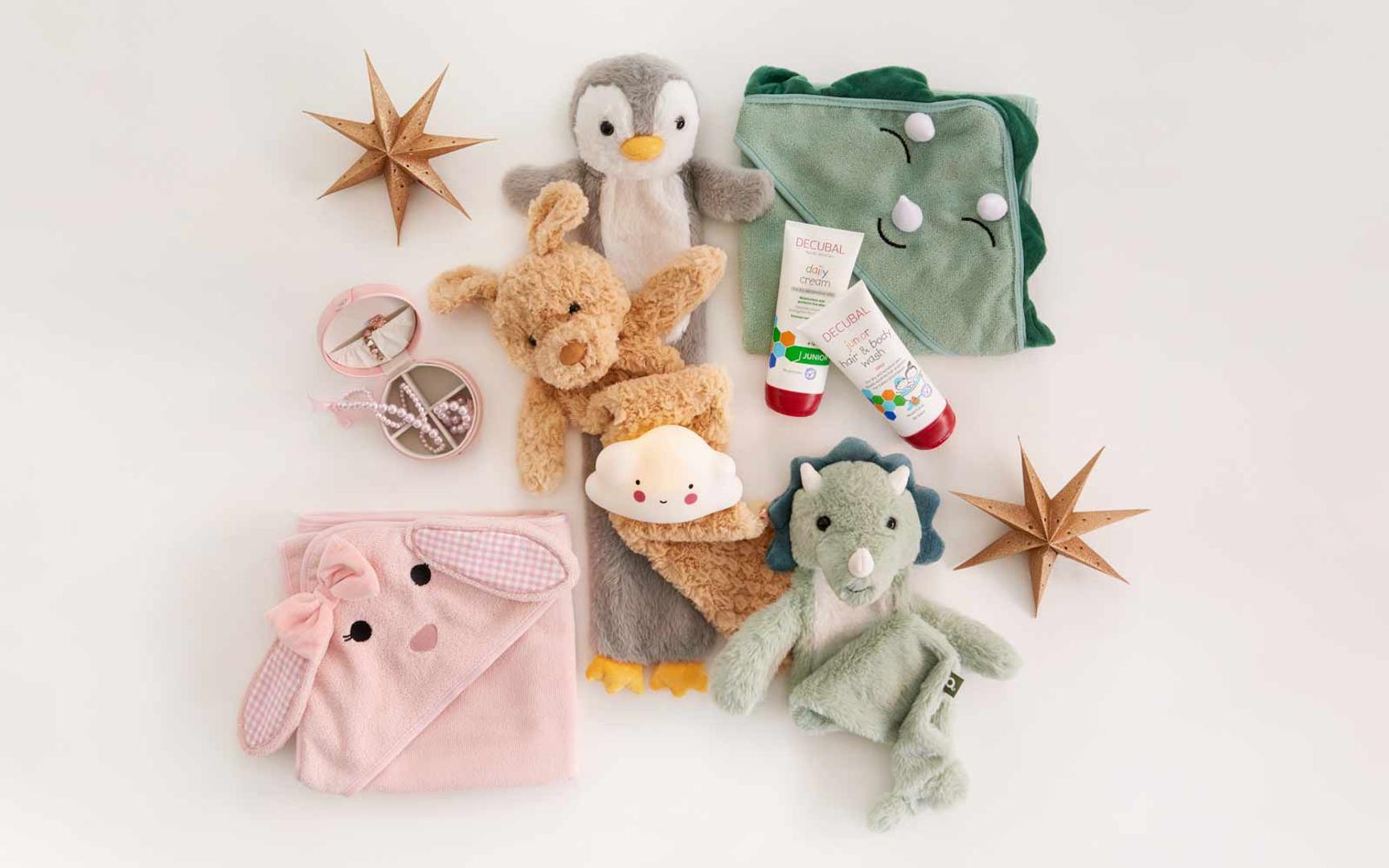 Bildet viser et utvalg søte barne- og babyprodukter lagt pent utover et lyst underlag