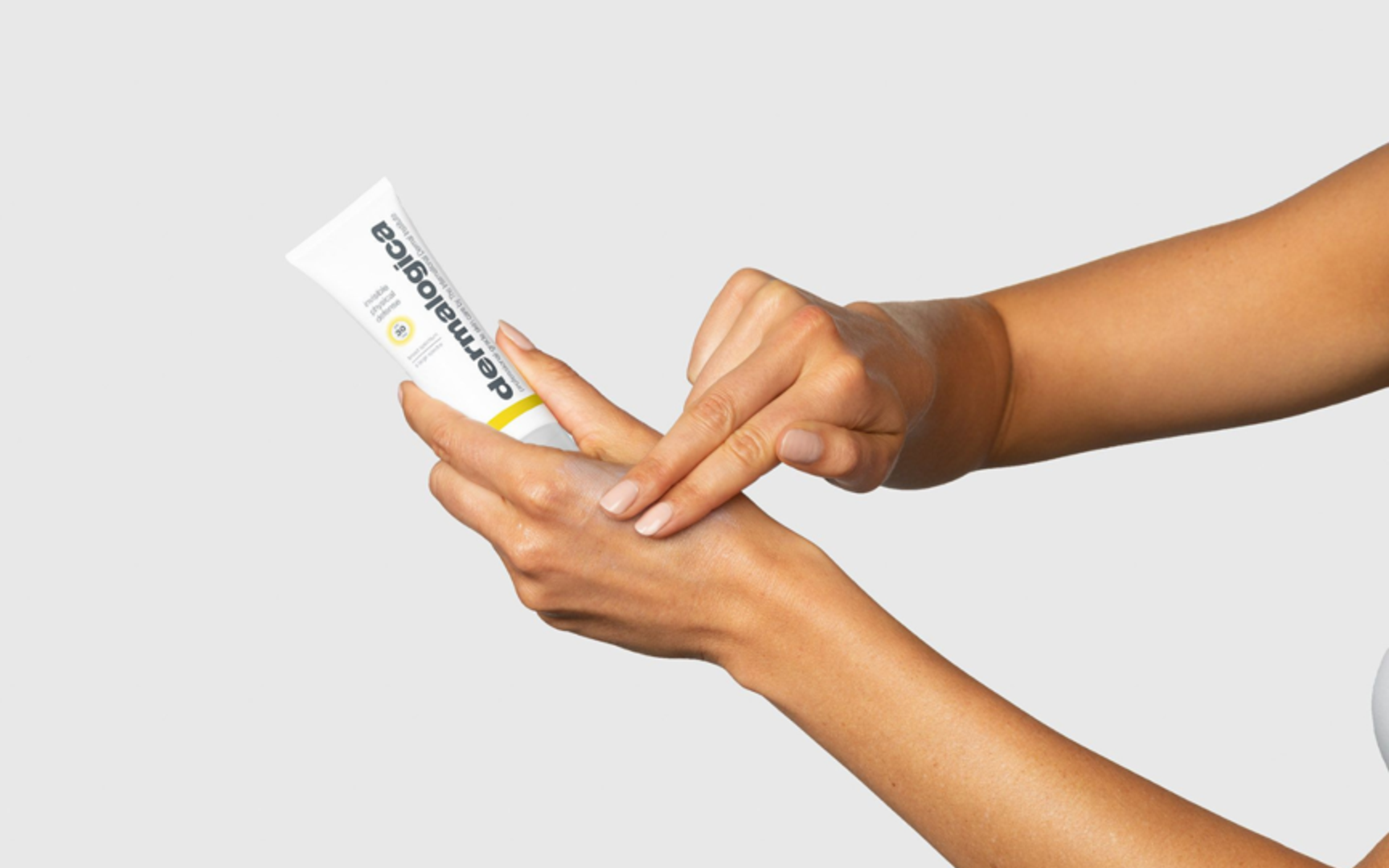 Hender som holder et Dermalogica solprodukt