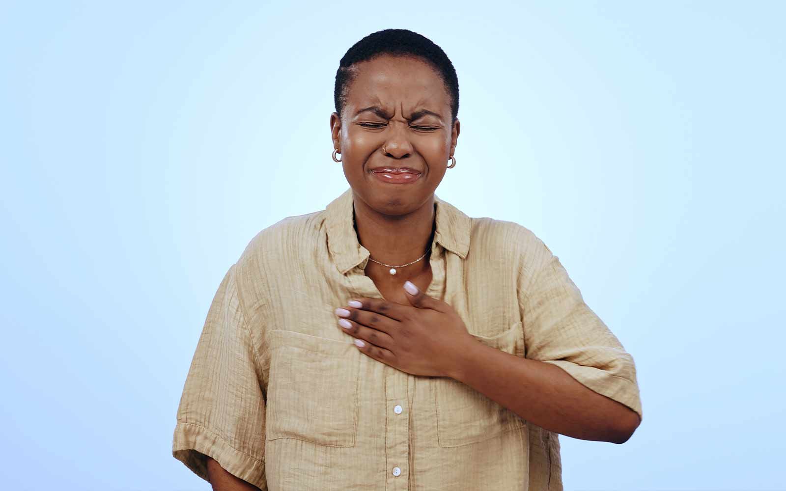 Kvinne som tar seg til brystet