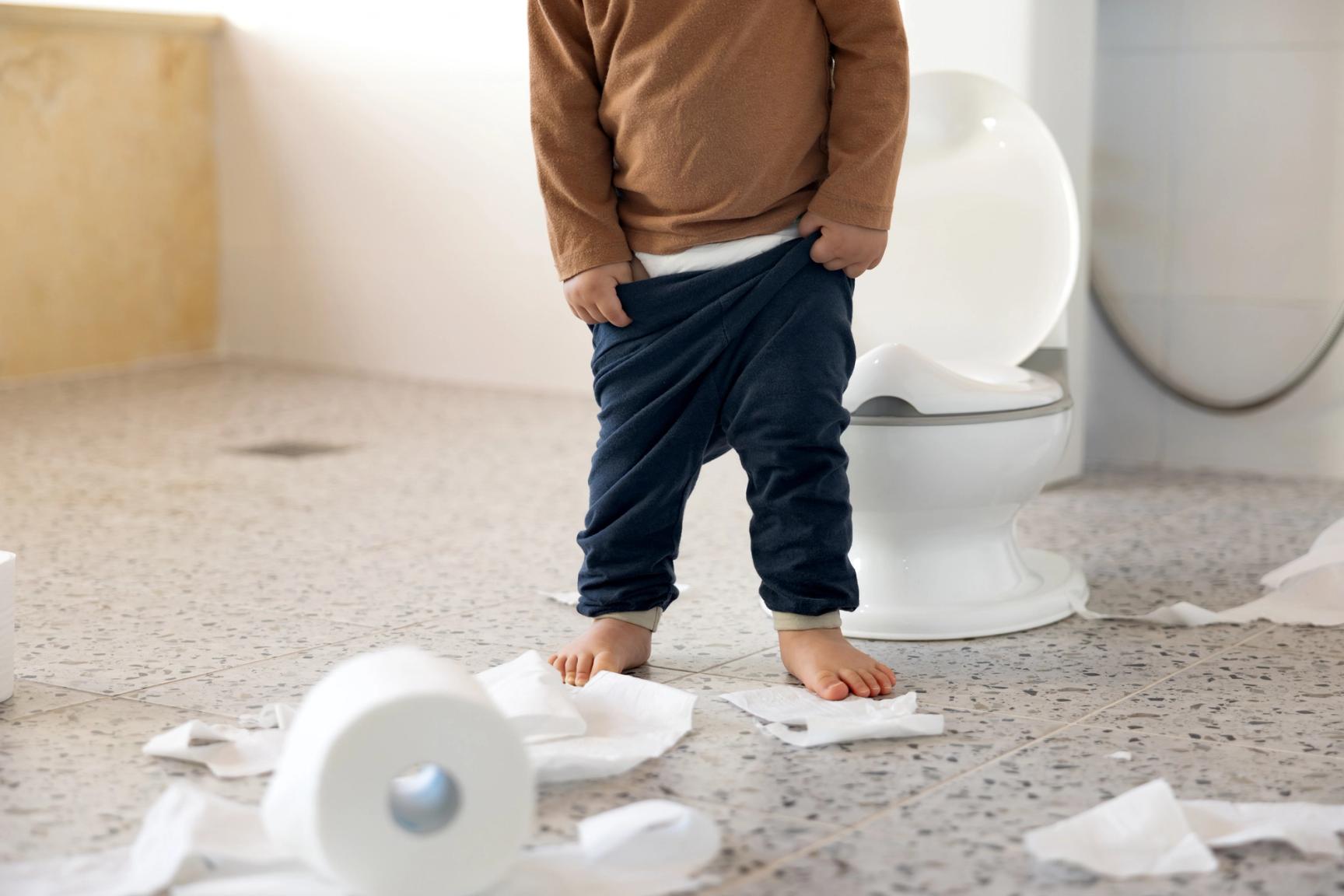 Lite barn står foran et toalett