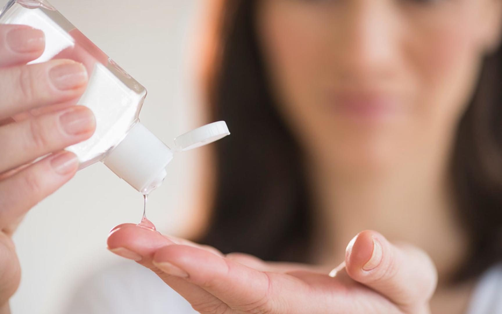 Dame som har på antibac i hendene