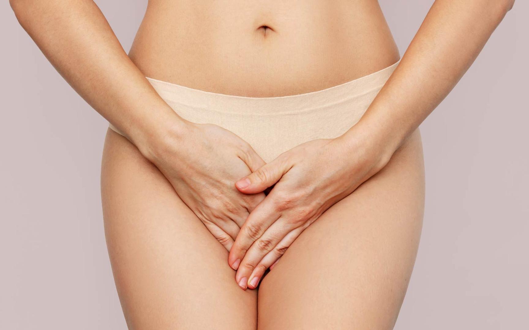 Kvinne iført beige truse holder hendene i kryss over underlivet. Bare kvinner får bakteriell vaginose, og tilstanden skyldes bakteriell ubalanse.